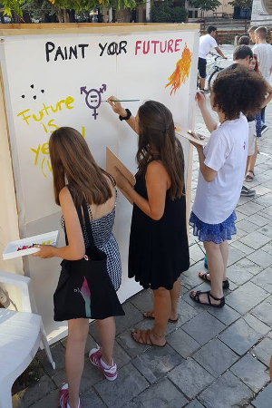 Young girls painting their creative visions of the future on the Paint your Future Canvas. Photo:  UN Women/Solene Moutier 