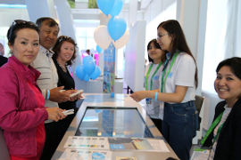Visitors at UN Women booth at EXPO 2017 supporting gender equality. Photo: UN Women/Aijamal Duishebaeva 