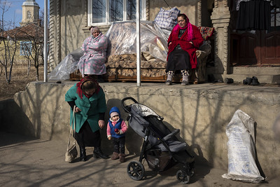 Daily life scenery. Members of Bucur family, who offered shelter to a Roma family of 10 from Ukraine, is enjoying the sun in their courtyard. Drochia, Moldova. Photo: UN Women