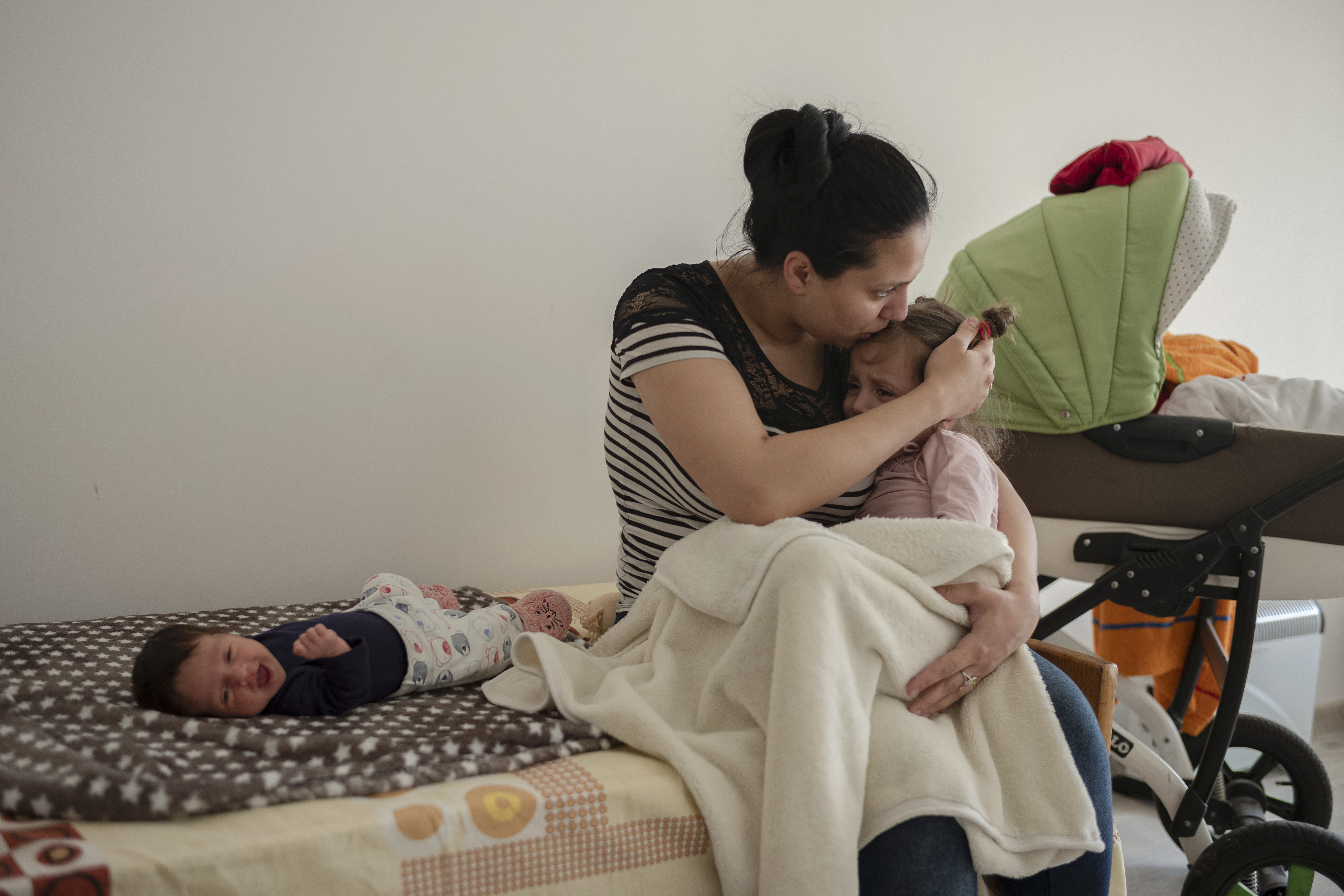 Svetlana Babaș with her two daughters, newborn Adelina (left) and 3-year-old Sofia (right), in the refugee center in Straseni, Moldova  . Photo: UN Women/Maxime Fossat