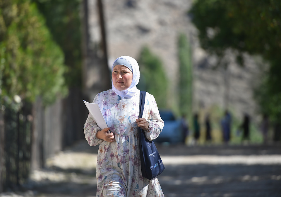 Aida on her way to attend a meeting with women, girls and local authorities to discuss the role and contribution of women migrants to peacebuilding and development. Photo: UN Women/Alisher Aliev