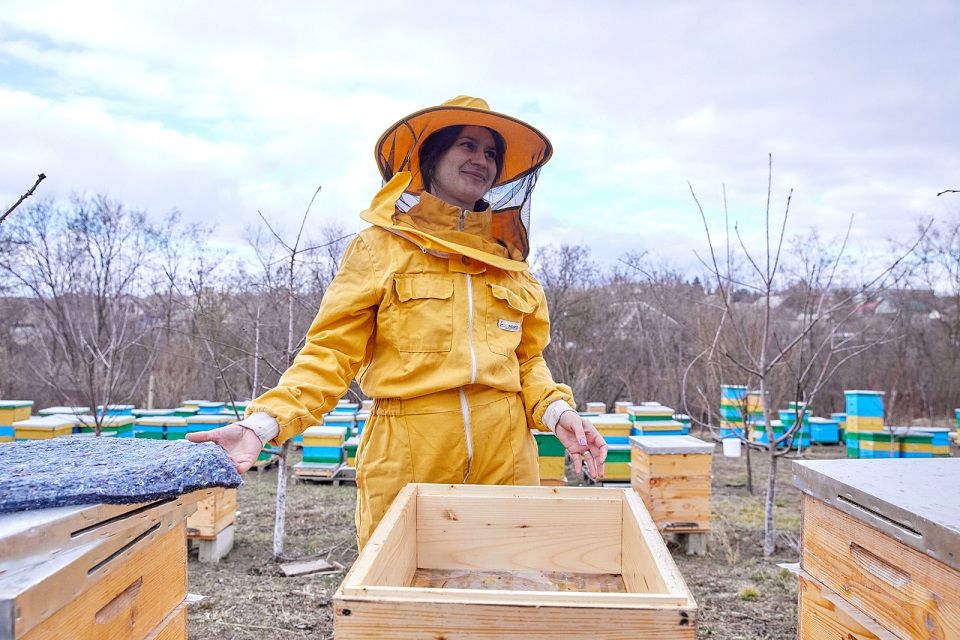 Cristina Bacaliuc inspects one of her hives. Photo: UN Women Moldova
