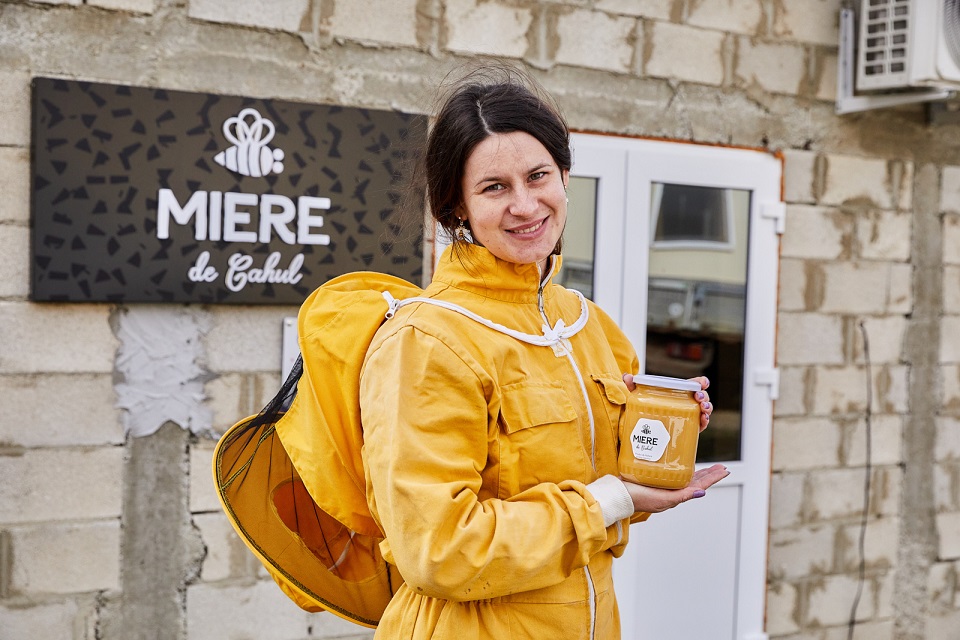 Cristina Bacaliuc shows off one of her products, a pot of honey. Photo: UN Women Moldova