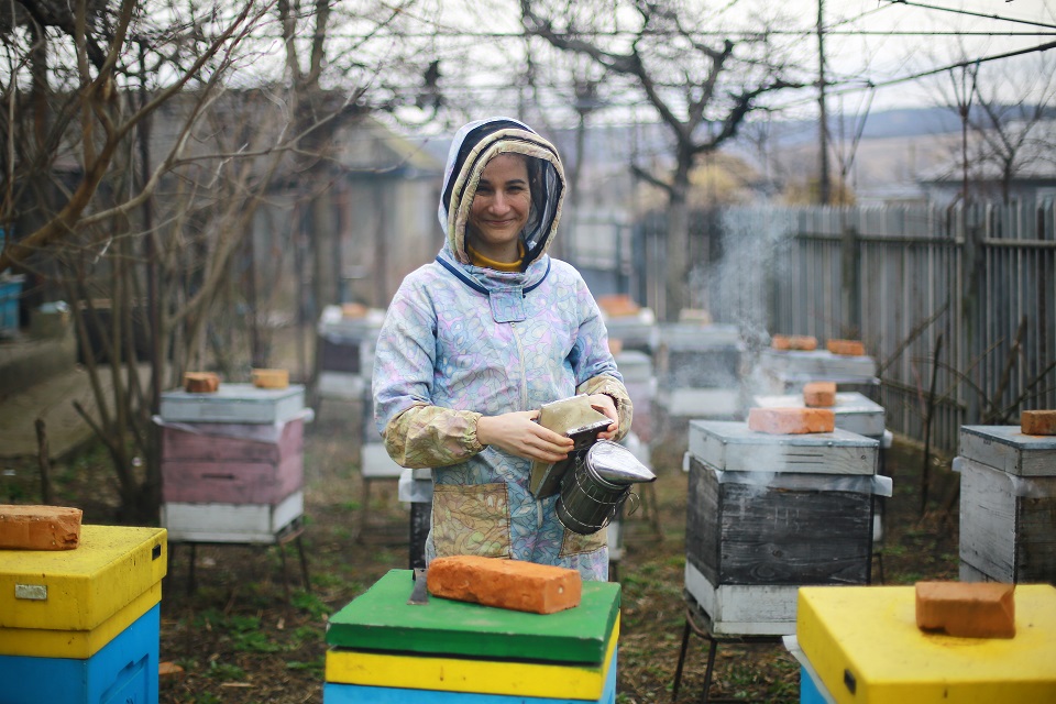 Liza Mămăligă stands amid the colourful beehives in her apiary. Photo: UN Women Moldova