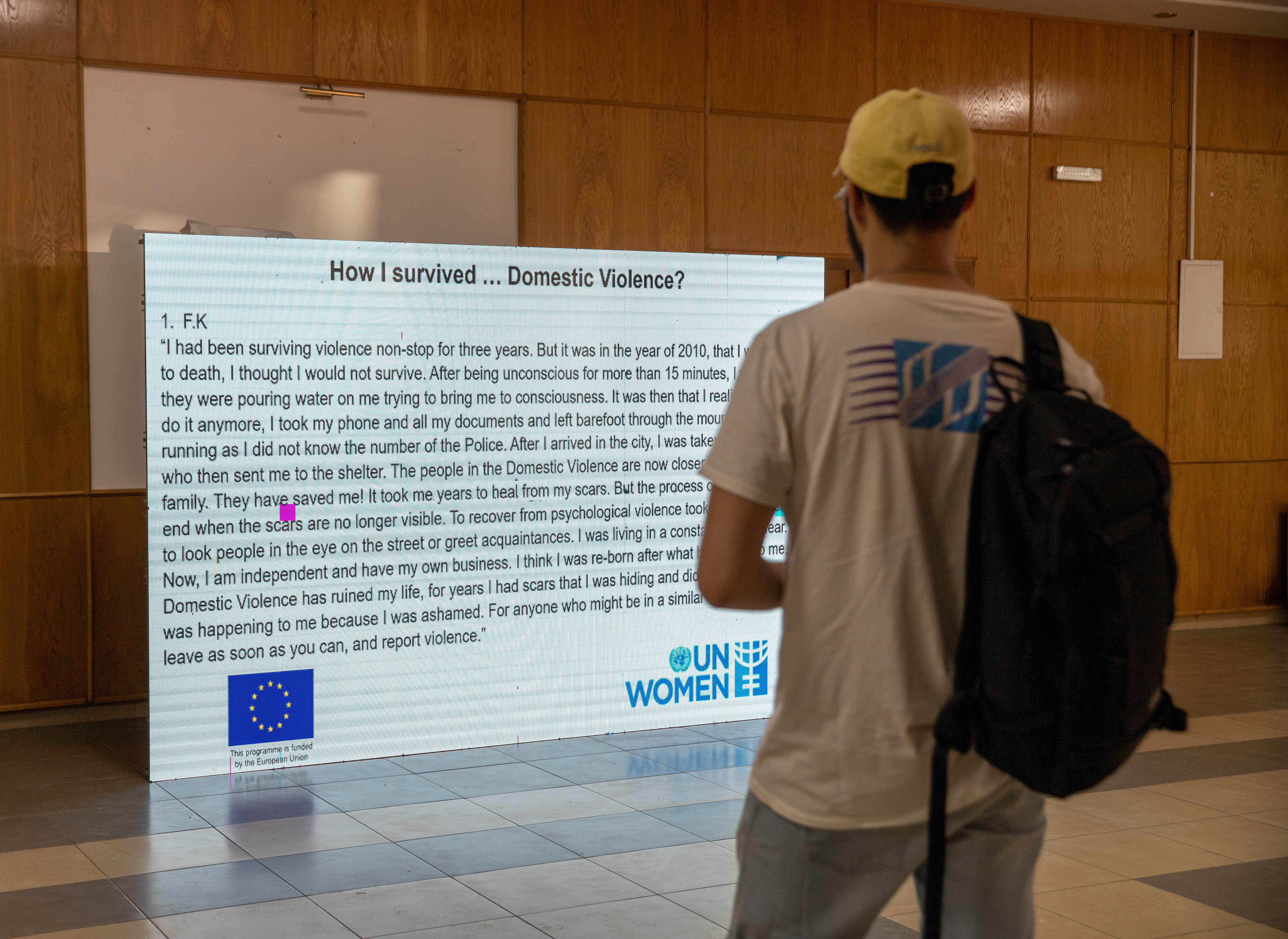 A visitor reads one of the stories of survivors of domestic violence displayed at Dokufest. Photo: UN Women Kosovo.
