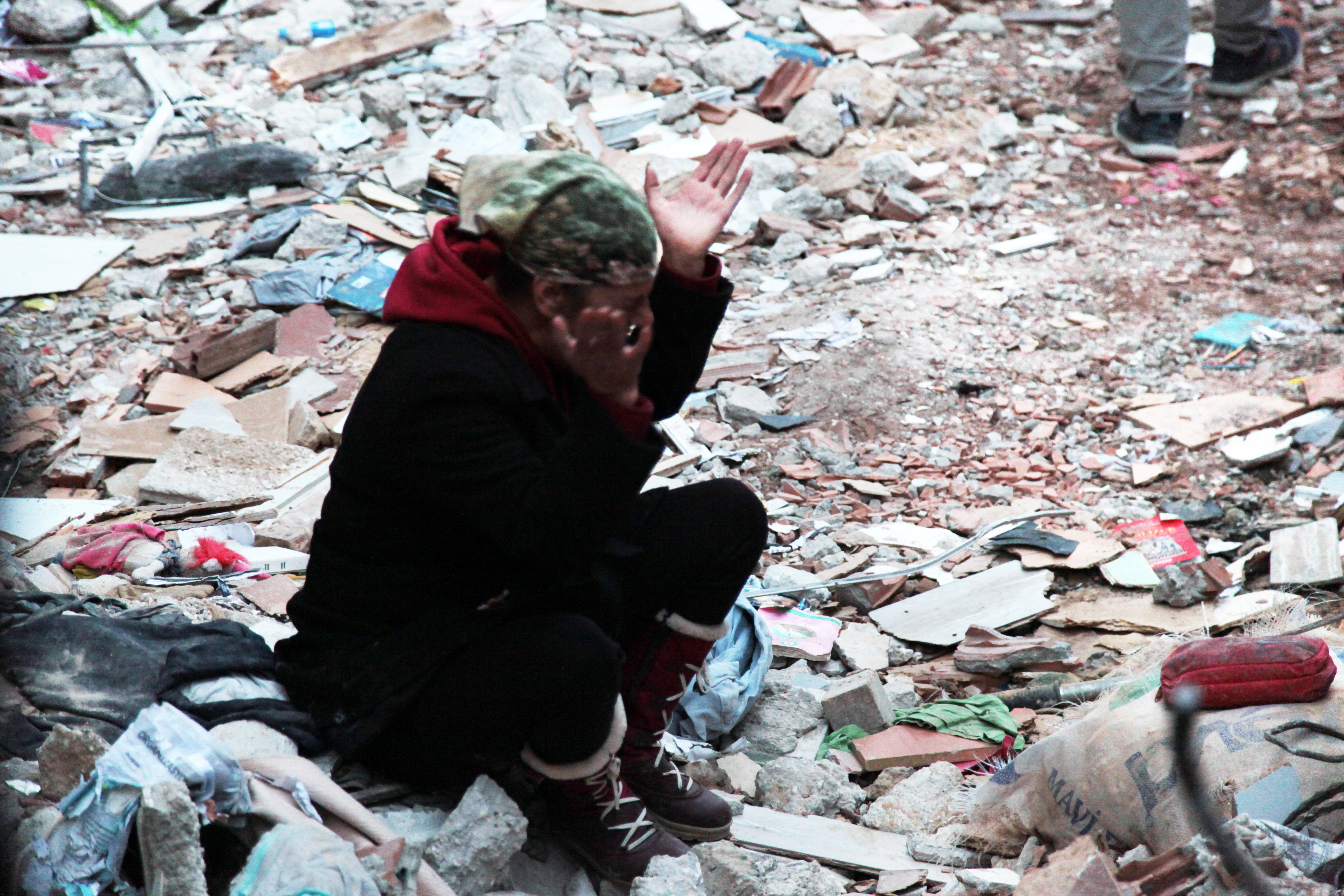 A woman mourns in front of her collapsed house in Hatay. Photo: Özge Ergin.