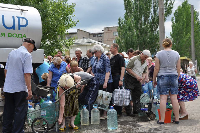 Жители пострадавшего от конфликта города Стаханов Луганской области Украины получают питьевую воду. Фото: ЮНИСЕФ Украина