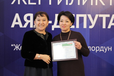 Ainuru Altybaeva, MP- active gender advocate in the Kyrgyz parliament, awarding with a certificate a newly elected woman-deputy of the local council. Photo: UN Women Kyrgyzstan/Meriza Emilbekova