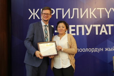 Gerald Gunther, UN Women Representative in Kyrgyzstan, awarding with a certificate a newly elected woman-deputy of the local council. Photo: UN Women Kyrgyzstan/Meriza Emilbekova