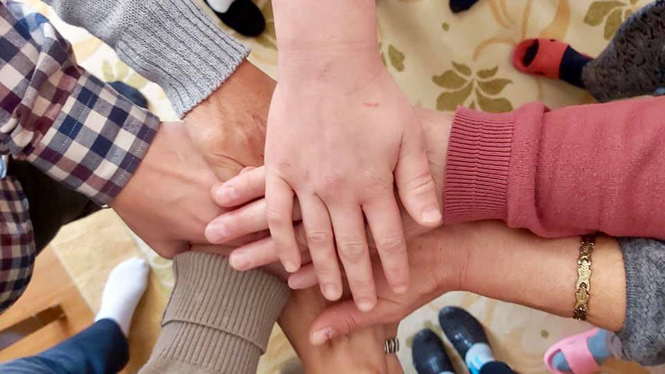 Survivors hold hands after the sessions of psycho-social support. The aim of these sessions was to help women and children actively integrate into the society after tackling the trauma they experienced. Photo: Safe House Gjakova