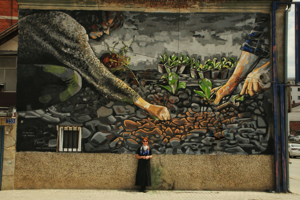 Lebibe Topalli, in front of her mural “What you sow, you reap” as part of the UN Women regional initiative Mural Artivism; breaking the walls of gender inequality. Photo: Donit Avdyli / Mural Fest