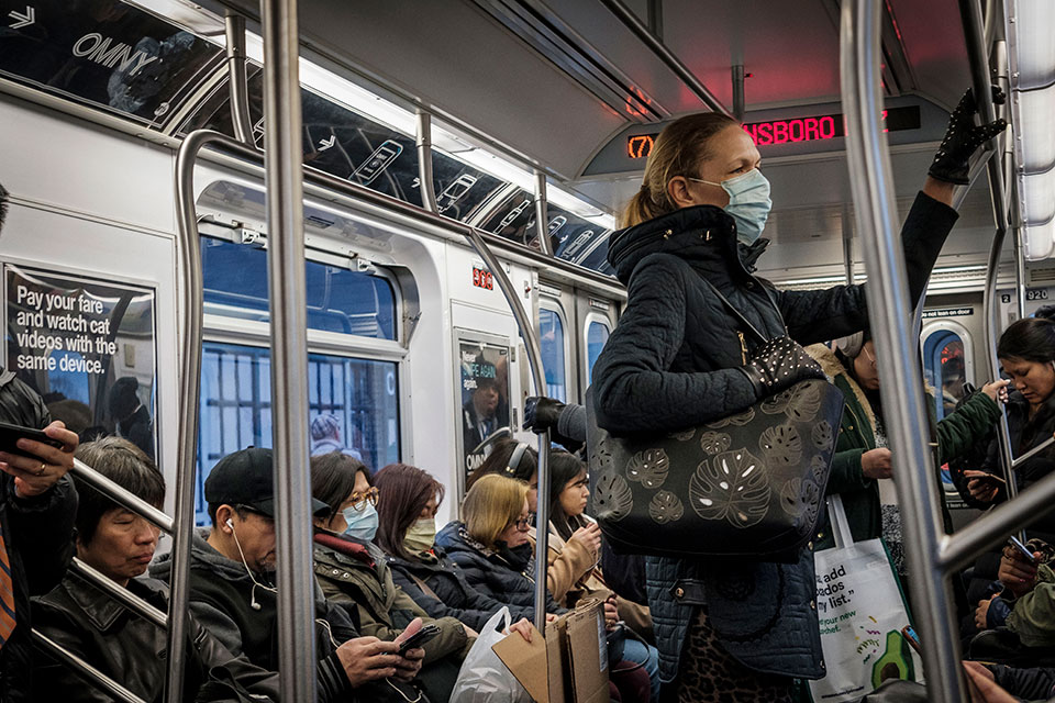 A women on public transit in New York wears face mask in March 2020, when many appear to be doing so as a precaution against COVID-19.  Photo: UN Photo/Loey Felipe